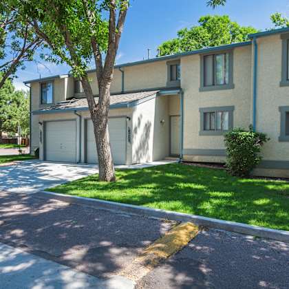 a sunny day at a residential area with apartment buildings and green trees.