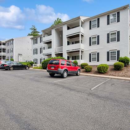 parking lot in front of a white apartment building.
