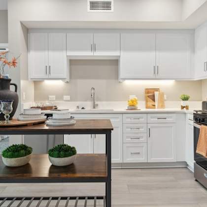 a kitchen with white cabinets and an island at arrive temecula