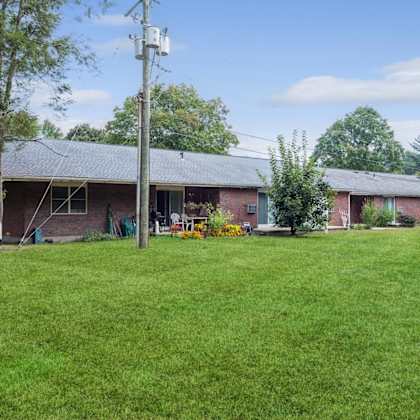 a view of the front of a brick house with a green yard