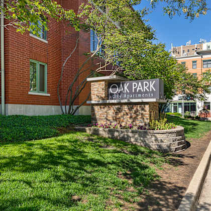 a sign for oak park apartments is in front of a brick building. at oak park city, oak park illinois