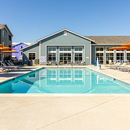a swimming pool with chairs and umbrellas next to a building at arrive paso robles, california, 93446