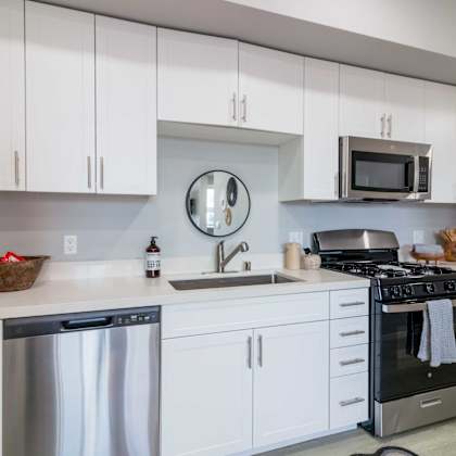 a modern kitchen with white cabinets and stainless steel appliances.