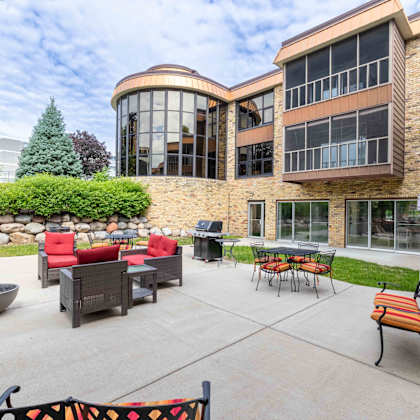 a patio area with a table and chairs outside a building.