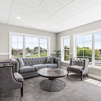 sitting room with couches and chairs and large windows at lofts at 335, stratford, ct