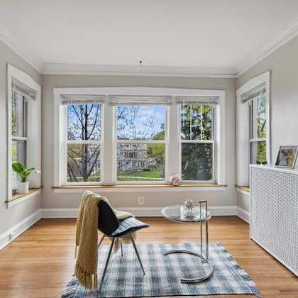 a living room with a chair and a table in front of a window at the bryant at oak park i & ii, oak park