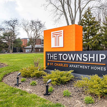 a sign that says the townships at the entrance to a lawn with trees in the backgroundat the township at st. charles, st. charles, illinois