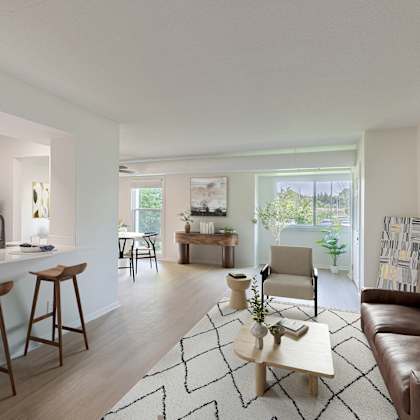 a modern living room with a brown leather couch and a white kitchen area.