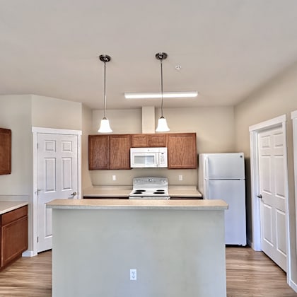 a kitchen with white cabinets and a white fridge.
