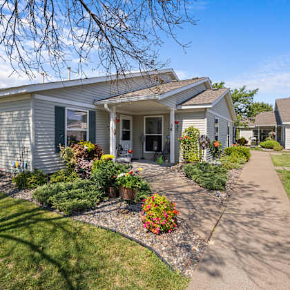 a blue house with a sidewalk in front of it