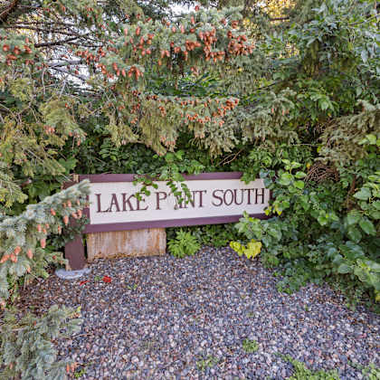 a sign for lake path south in front of some trees