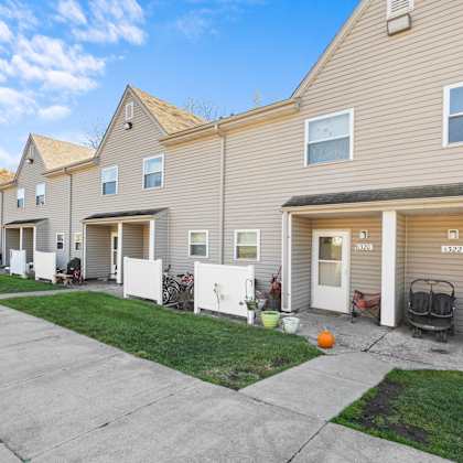 a row of houses with garages and front yards.