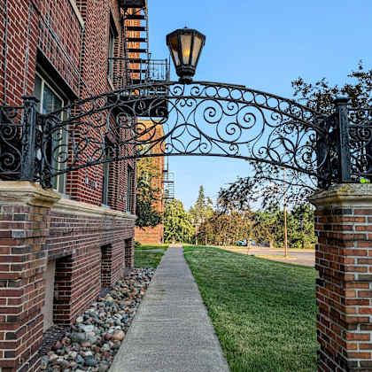 an ornate wrought iron gate on the side of a brick building