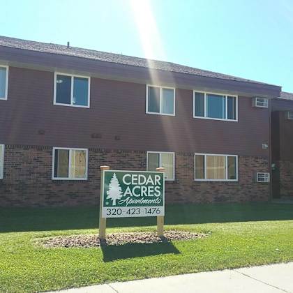 a building with a sign that says cedar acres and a phone number.