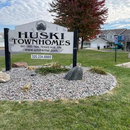 a sign for huski townhomes with a phone number and website.