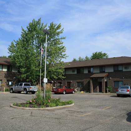 a parking lot in front of a building with cars parked.