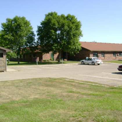 a parking lot with cars and a building in the background.