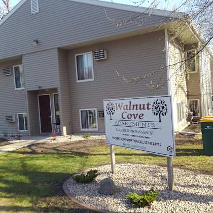 a sign for walnut cove apartments is in front of a building.