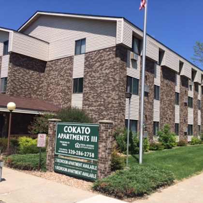 a building with a sign that says cokato apartments iii.