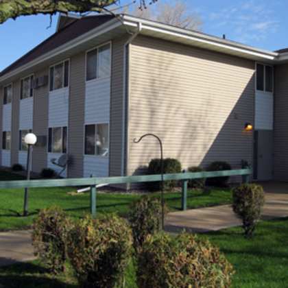 a building with a green fence in front of it.