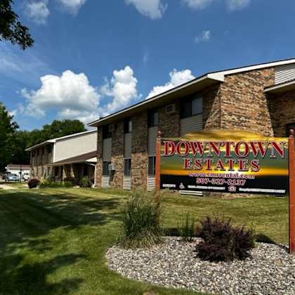 a sign for down town estates is in front of a building.