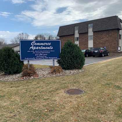 a sign for commerce apartments is in front of a brick building.