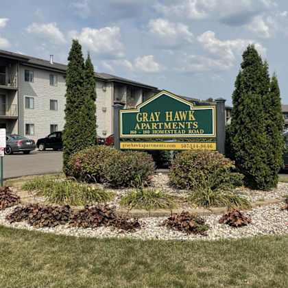 a sign for gray hawk apartments is in front of a building.