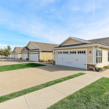 a row of houses with garages and driveways.