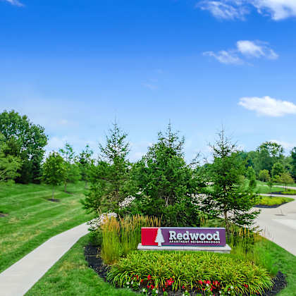 a sign that says redwood in front of a grassy area.