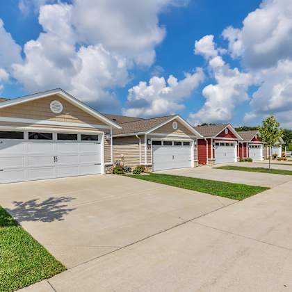 a row of houses with garages and driveways.