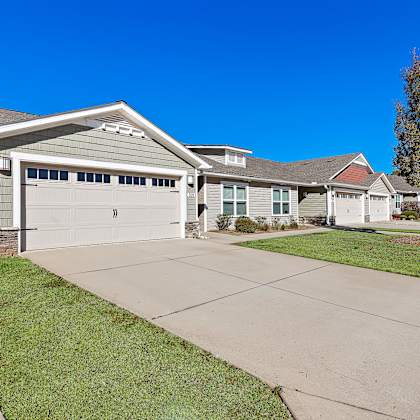 a house with a grey garage door and a grey roof.