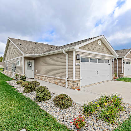 a house with a grey roof and a white garage door.