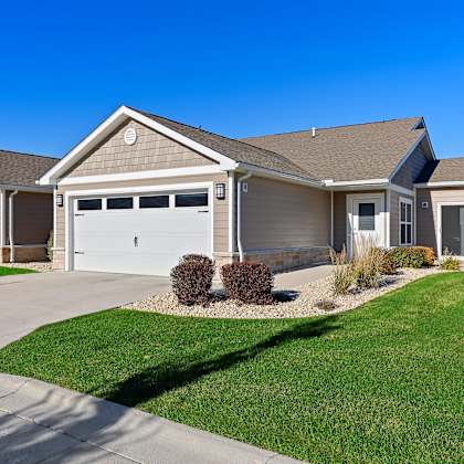 a two-story house with a garage and a driveway.