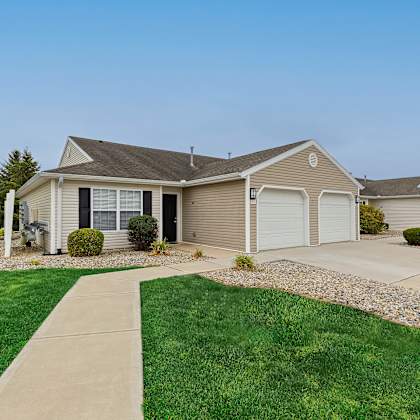 a house with a grey roof and a white garage door.