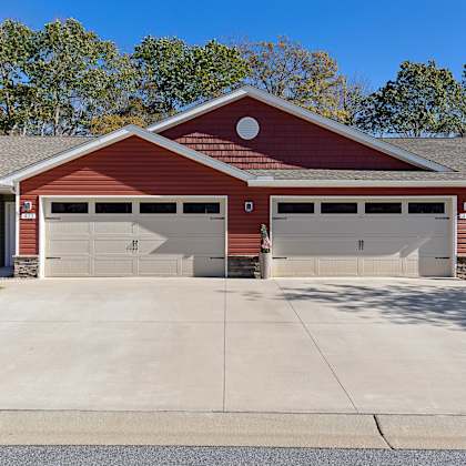 a two-car garage with a red brick exterior and a grey roof.