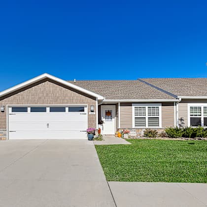 a house with a grey roof and a white garage door.
