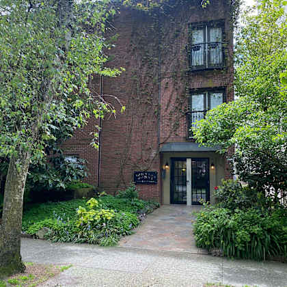 a red brick building with a black sign in front of it