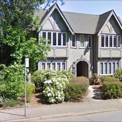 a large house with a sidewalk in front of it