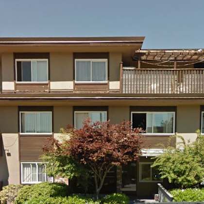 a large apartment building with trees in front of it
