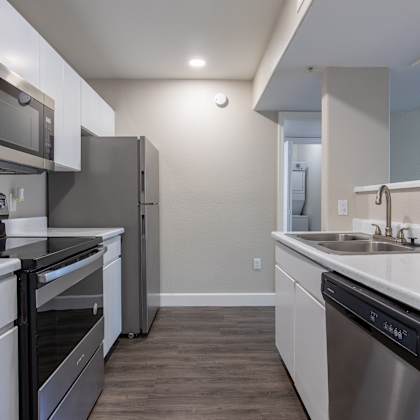 a kitchen with white cabinets and stainless steel appliances