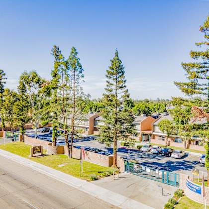 a view of a parking lot with trees and buildings