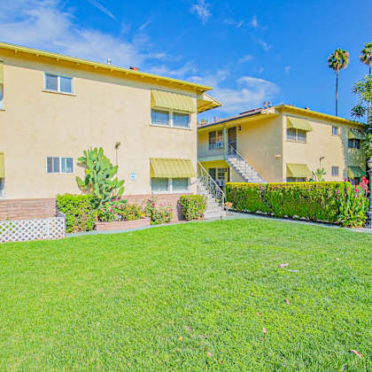 a house with a green lawn and a sign in front of it