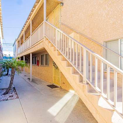 the outside of a building with stairs and a palm tree