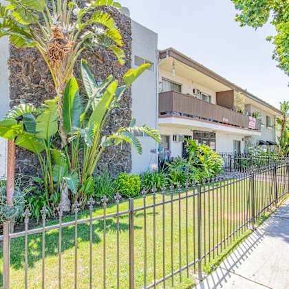 a house with a yard and a fence in front of it