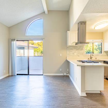 an empty kitchen with a stainless steel refrigerator and a sink