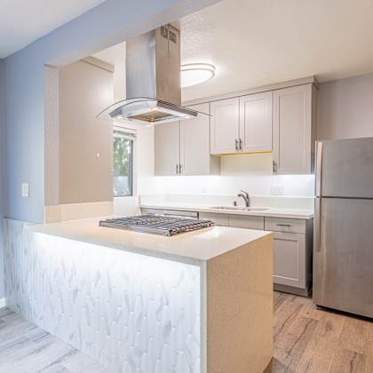 a kitchen with white cabinets and a stainless steel refrigerator