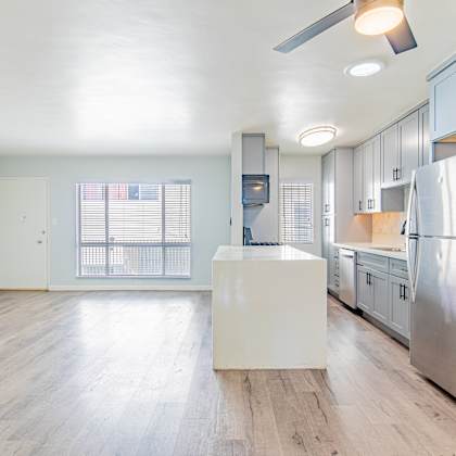 a renovated kitchen with stainless steel appliances and white cabinets