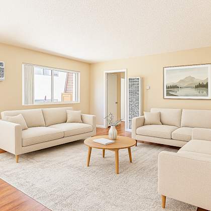a living room with two couches, a coffee table, and a painting on the wall.