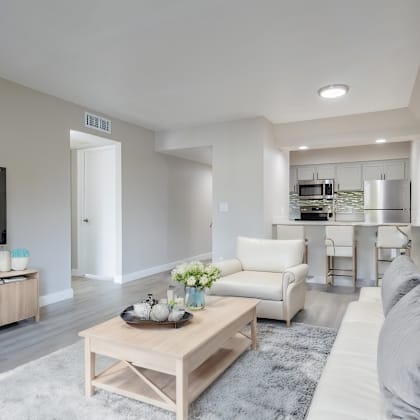 a modern living room with a white sofa and a wooden coffee table at sofia apartments, tempe, 85283