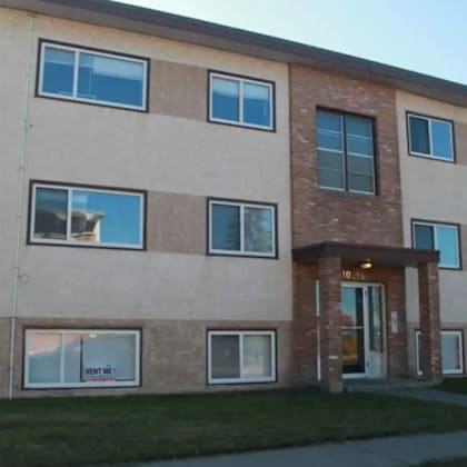 a building with a cat sitting in one of the windows.